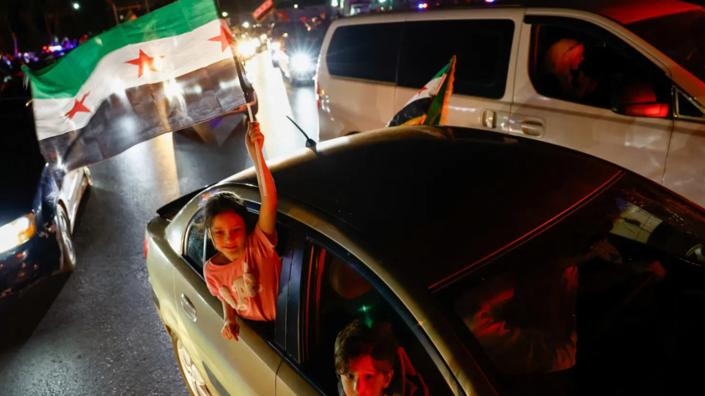A girl holds a Syrian flag, as people celebrate after U.S. President Donald Trump said on Tuesday. May 13 , 2025. Yamam Al Shaar | Reuters